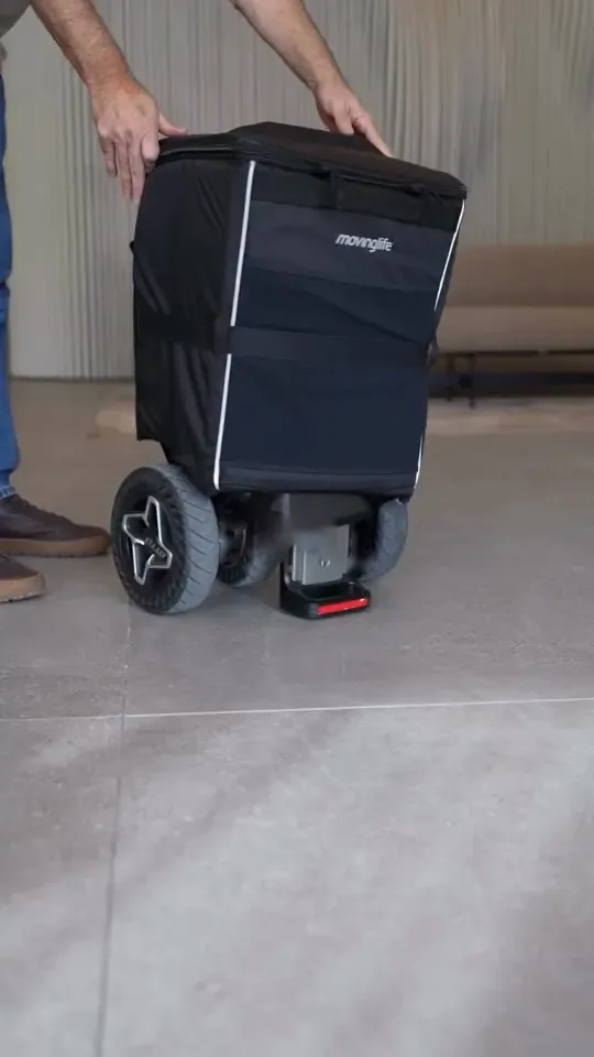 The ATTO scooter folded in trolley mode, covered by the MovingLife flight kit bag